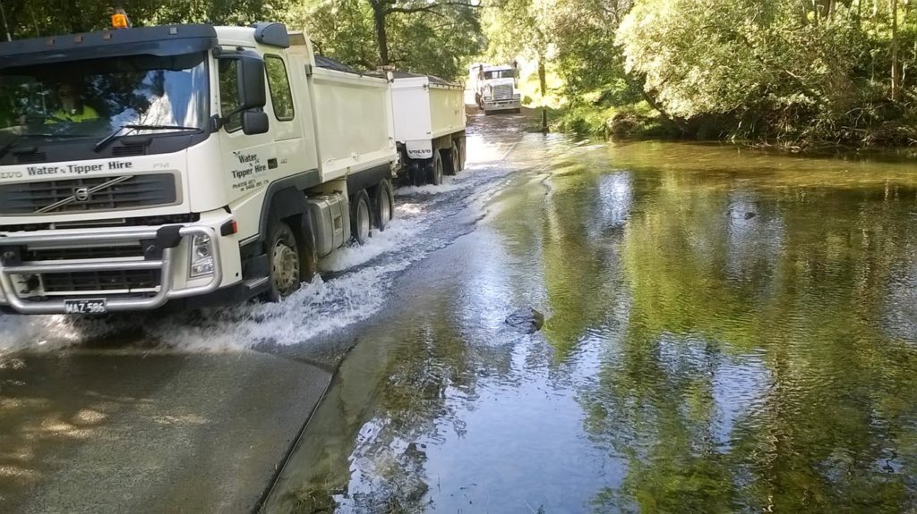 Gallery Image of Tip trucks driving through creek Tipper Truck Water N Tipper Hire Gloucester NSW