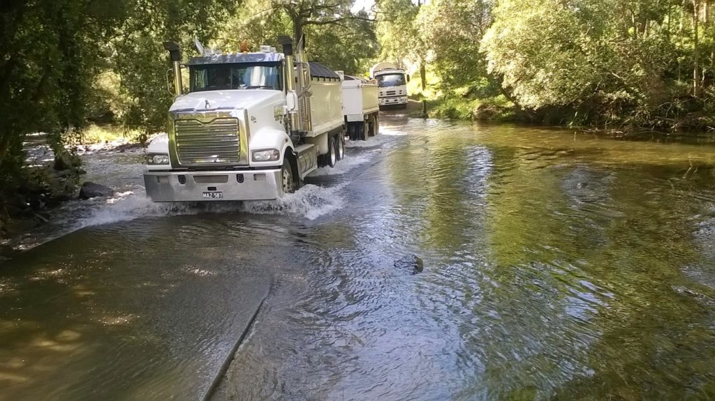 Gallery Image of Tip trucks driving through creek Tipper Truck Water N Tipper Hire Gloucester NSW 2422